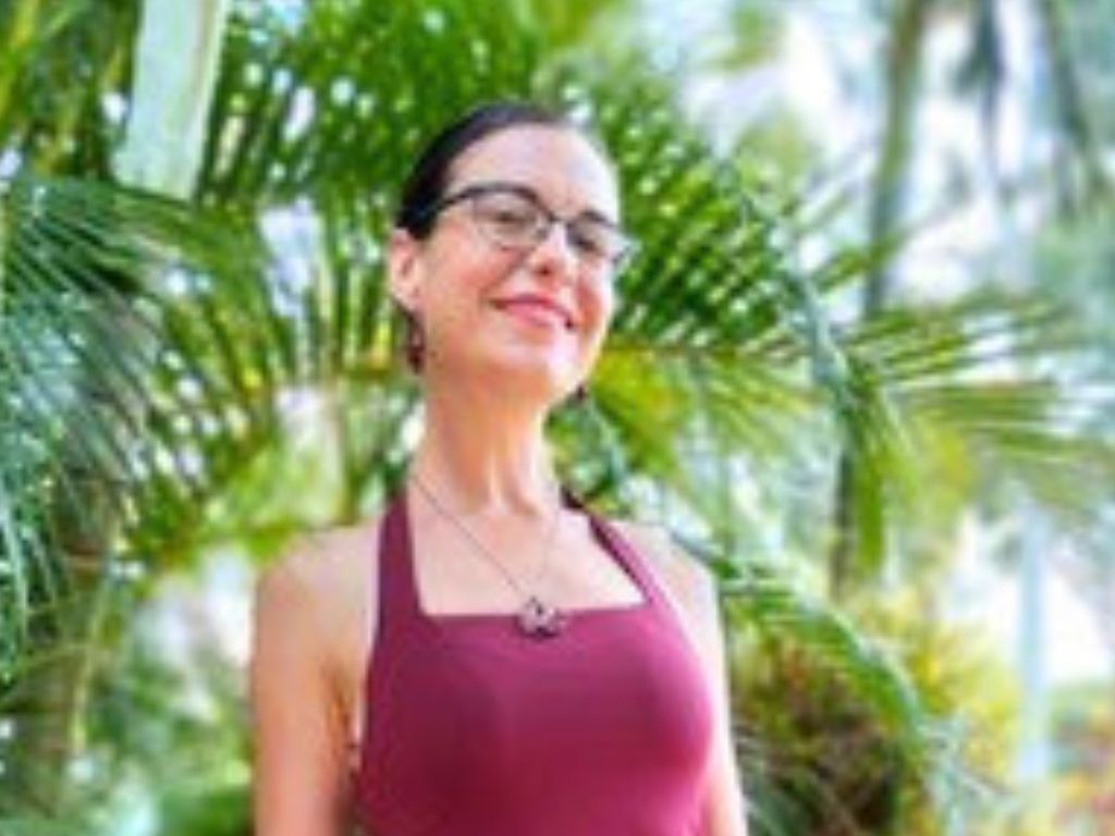 MH4L participant Clarisse standing in front of greenery, looking at camera