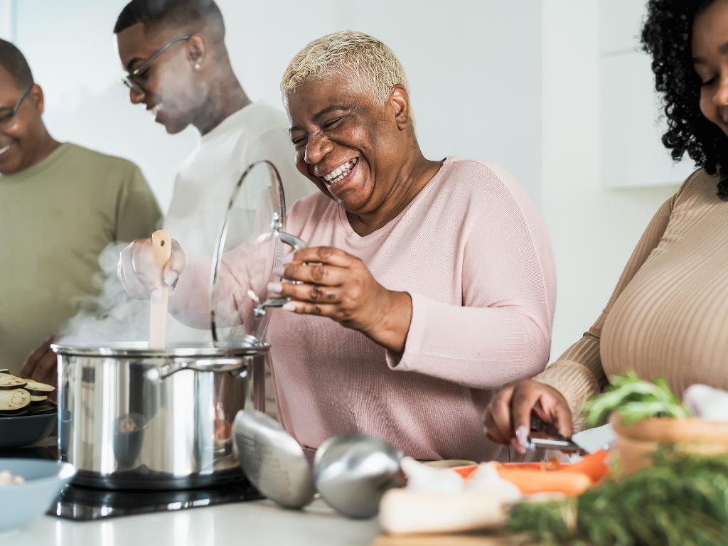 A lady making a meal in the kitchen and is smiling